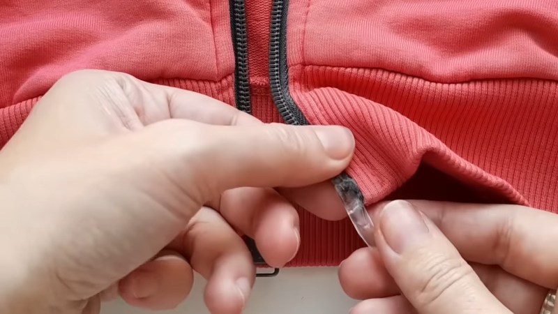 Fixing a hoodie zipper with a drinking straw and hot glue.