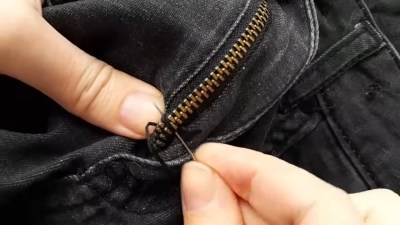 Sewing the teeth of a zipper together after cutting the tape just enough to slide the head back on. 