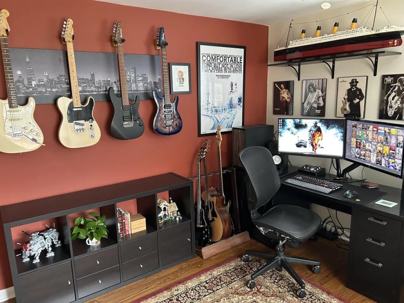 A cozy corner with guitars on the wall, more guitars in a rack, and, oh yeah -- a desk with a keyboard and stuff. But yeah, it's mostly guitars.