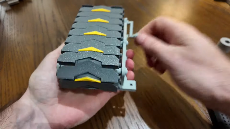 A 3D-printed, hand-cranked, toy conveyor belt designed after the transporter belts in Factorio.