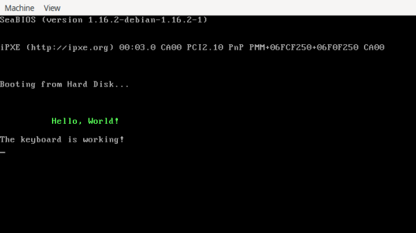 A console is shown displaying a system’s startup information, followed by “Booting from Hard Disk …”, “Hello World!” in a green font, and “The keyboard is working!”