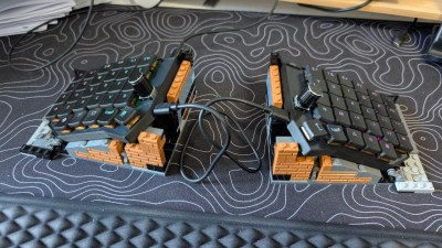 A split keyboard with LEGO built up to provide tenting.
