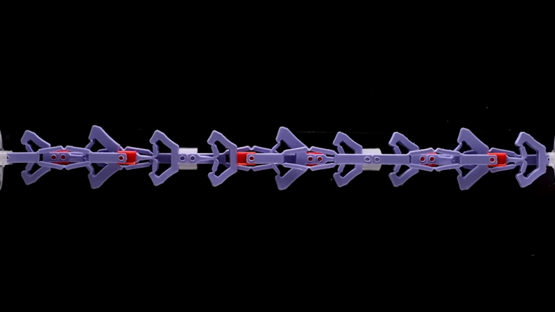 Series of purple and red mechanisms are stretched from left to right. Almost like arrows pointing right.