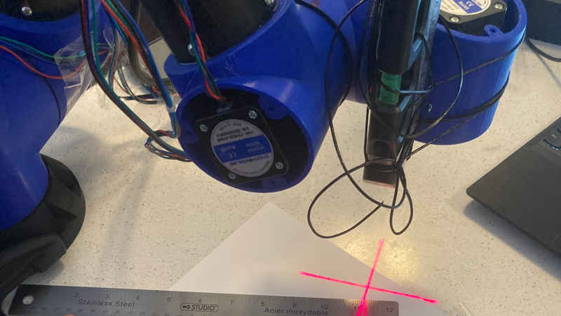 ManiPylator focusing its laser pointer at a page.