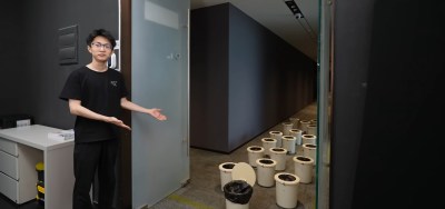A man standing next to a host of small automatic trash cans