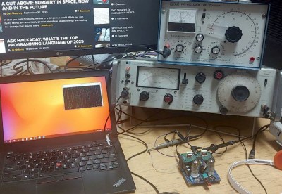 The Hackaday audio test bench. On the left, Thinkpad laptop, on the right, distortion analyser with audio oscillator on top of it. On the bench in front of the analyser, a small PCB that's the tube amplifier.