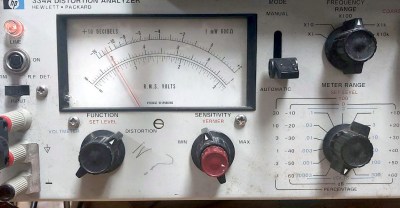 Part of the front panel of the HP 334A, showing a large panel meter and a set of dials.