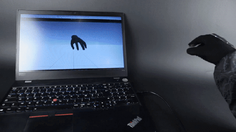 A person's hand wearing a black glove is shown in the right part of the image, making a series of gestures. A representation of a hand mimics those motions on a laptop screen.