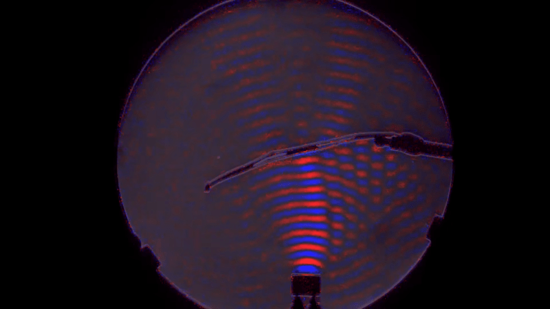 A red and blue visualization of the waves from a small ultrasonic speaker