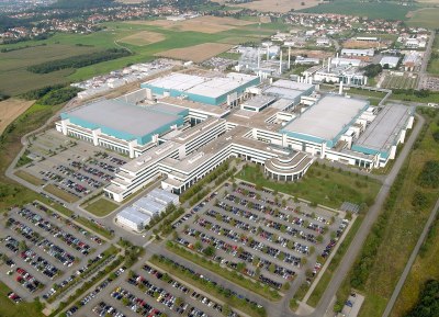 An aerial view of a very large factory surrounded by farmland