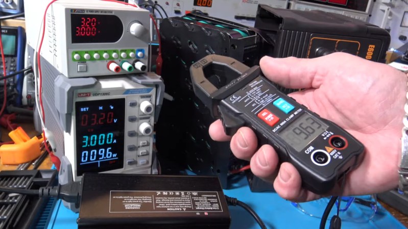 A hand holding the Zoyi ZT-QB9 Smart Clamp meter