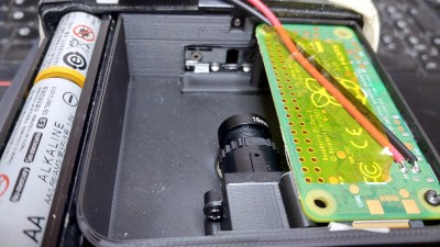 A 3D printed Super 8 cartridge inside a movie camera. On the right is a green Raspberry Pi Zero module, while in the foreground is an M12 lens camera module focusing on the film gate towards the back of the scene.