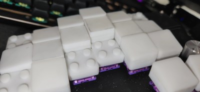 Height-adjustable keycaps in white, with tops removed to show the LEGO-like middles.