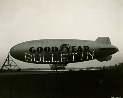 K-ship "Puritan" all decked out in lights. The sign reads "BULLETIN"