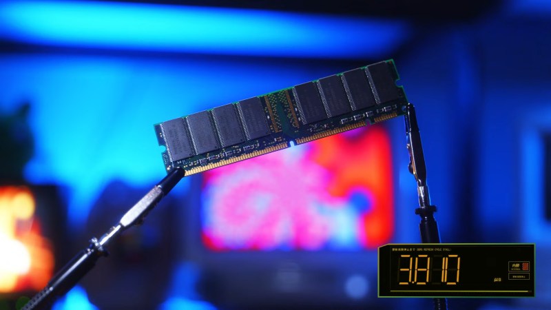 A stick of DDR4 in DIMM format held by some alligator clips