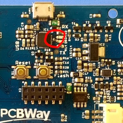 A picture of a printed circuit board covered with components, with a red ring drawn round a reworked part.
