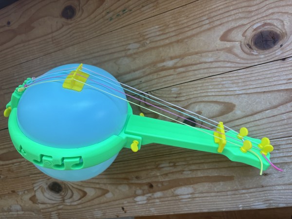 A small, 3D-printed banjo frame that uses a party balloon for the resonating chamber.