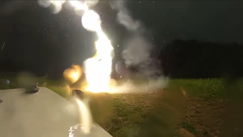 A lightning strike is shown striking the ground at close range (fewer than thirty feet away).