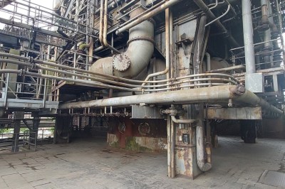 A maze of huge pipes on the side of a furnace
